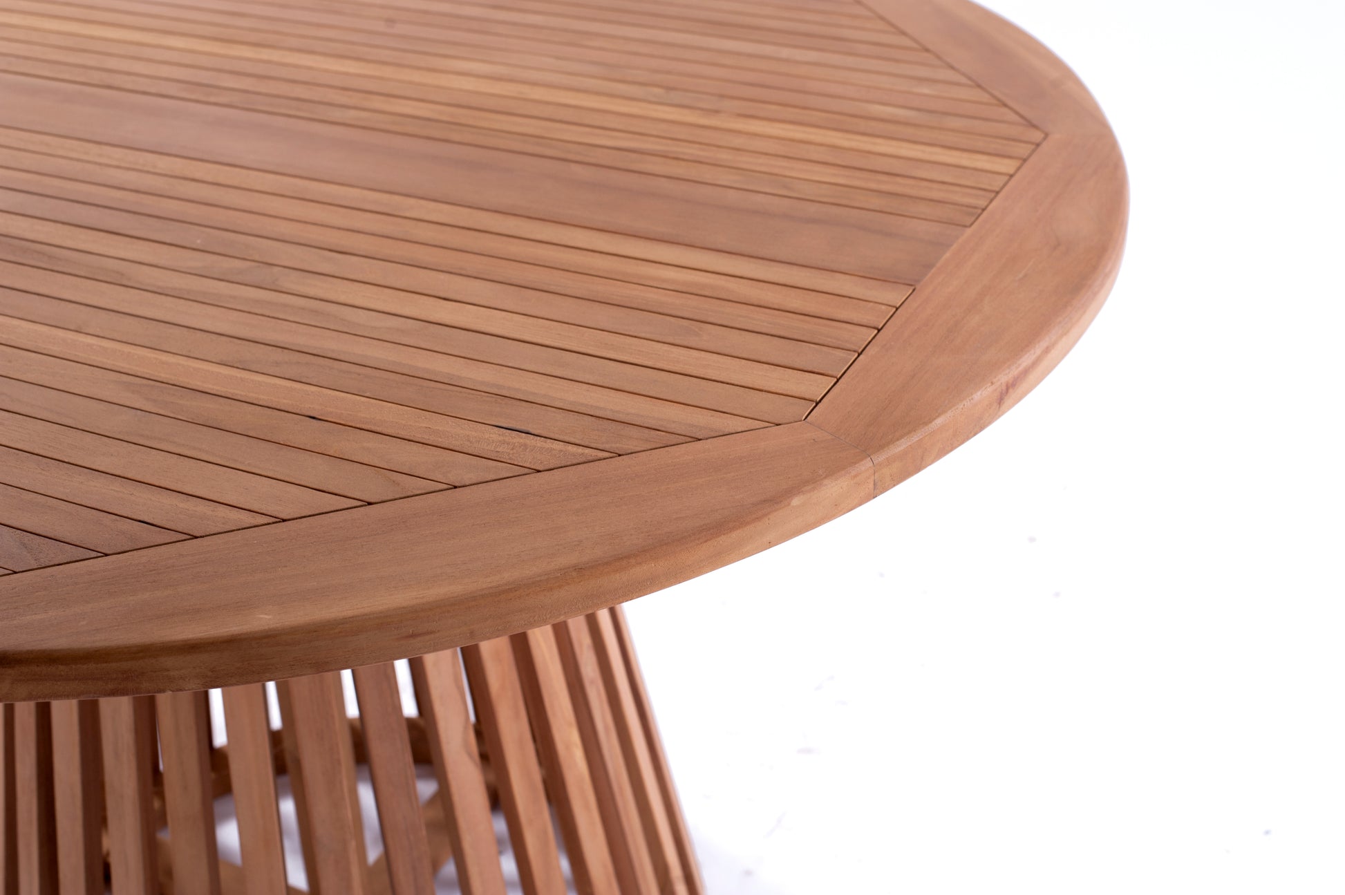 Nusa Dua round wooden outdoor dining table with slatted base, styled with white tableware and floral centerpiece on a garden patio deck.