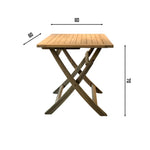 Cilacap square folding table in teak wood, placed on a sunlit patio with potted plants and a white house backdrop featuring black shutters and a large window