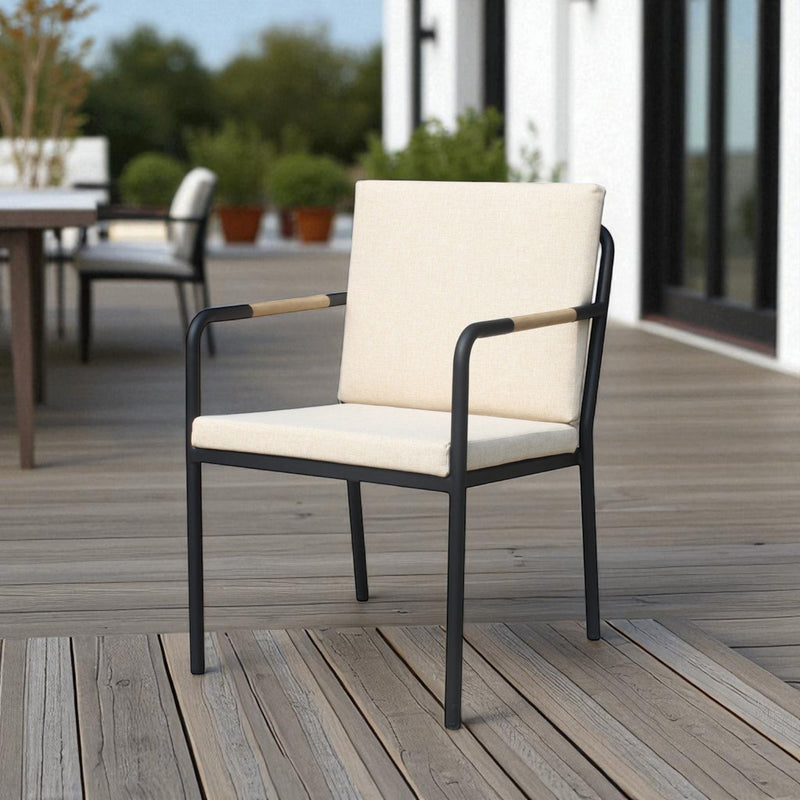 Hollviken outdoor dining chair with black metal frame, beige cushions, and wooden armrests on a modern patio deck.