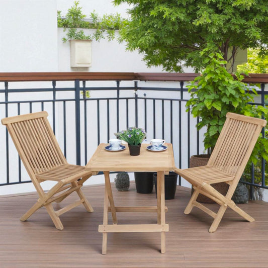 Teak outdoor balcony set featuring two Java Folding Chairs and a Cilacap Side Table with hexagonal top, styled with patterned teacups and potted flowers for a cozy patio vibe.