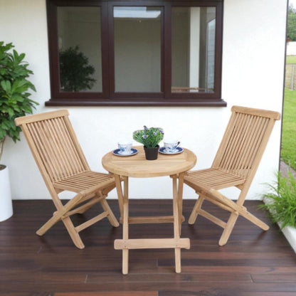 Teak outdoor balcony set featuring two Java Folding Chairs and a Cilacap Side Table with hexagonal top, styled with patterned teacups and potted flowers for a cozy patio vibe.