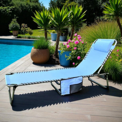 Foldable sun lounger with cushion and headrest on teak pool deck in tropical garden
