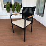 SKANÖR outdoor chair with black metal frame, wooden armrests, and beige cushion, ideal for modern patio or balcony seating