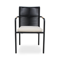 SKANÖR outdoor chair with black metal frame, wooden armrests, and beige cushion, ideal for modern patio or balcony seating